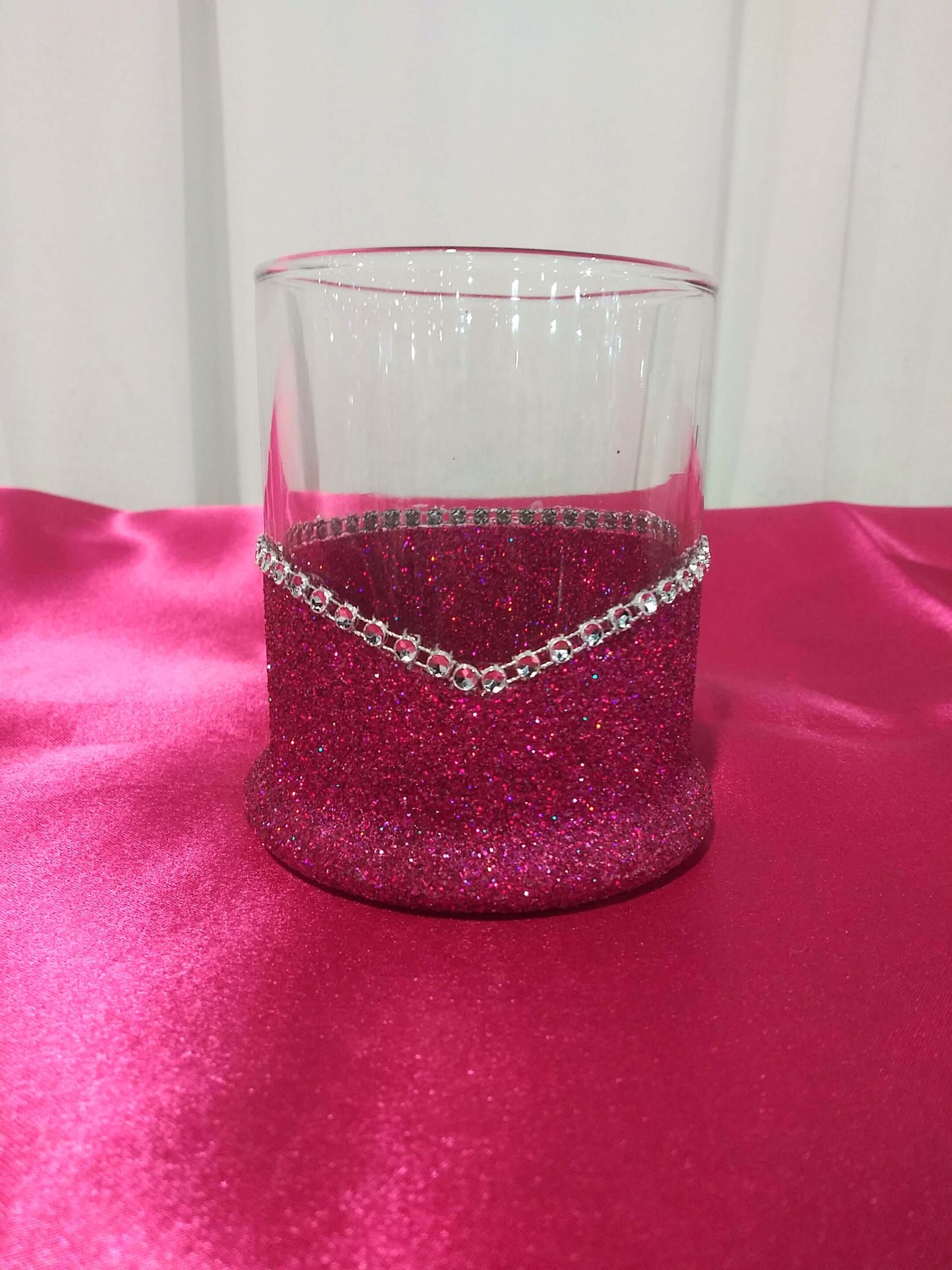 An elegant Fushia blinged highball glass with the phrase I Only Have Taste for Whiskey-Halloween Blinged Whiskey-Highball Glasses printed on it and decorated with glitter along the base, displayed on a pink surface.